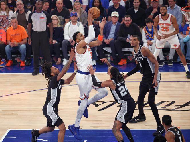 New York Knicks player Karl-Anthony Towns shoots the ball while being defended by San Antonio Spurs players Stephon Castle and Devin Vassell during Game 3 of the NBA Finals.